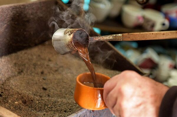 Кофе, сваренный в турке на песке, наливают в чашку - Sputnik Абхазия
