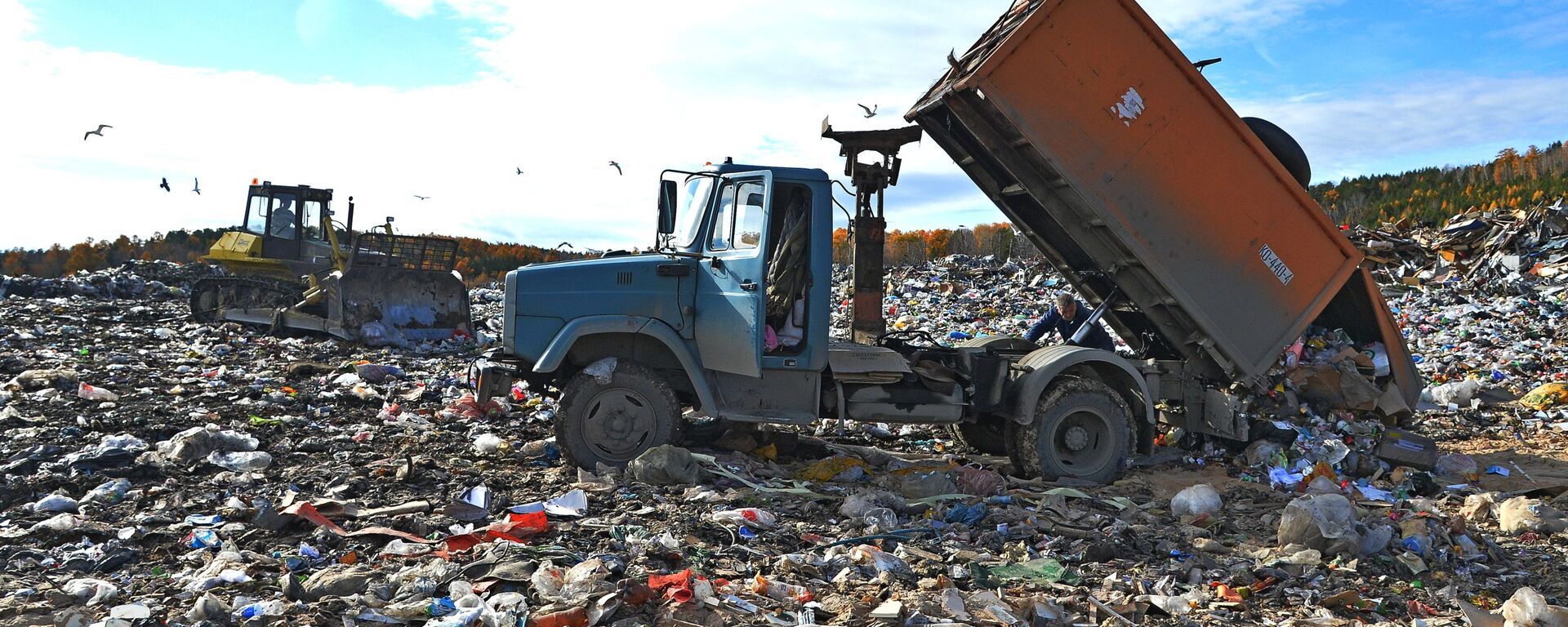Рабочие выгружают бытовой мусор для последующей утилизации на полигоне твердых отходов в городе Миасс - Sputnik Абхазия, 1920, 10.04.2024