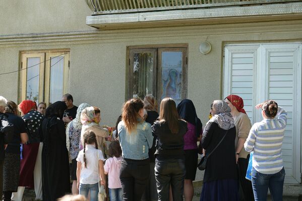 Люди молятся у дома на стекле которого появился лик Божьей Матери в селе Первый Гал - Sputnik Абхазия