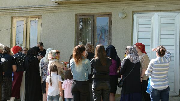 Люди молятся у дома на стекле которого появился лик Божьей Матери в селе Первый Гал - Sputnik Абхазия