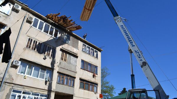 Ремонтно-восстановительные работы кровли в девятиэтажном многоквартирном жилом доме по улице Назадзе 19а в Старом поселке Сухума - Sputnik Аҧсны