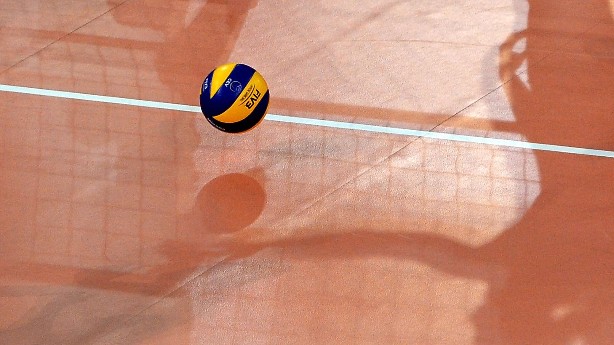 Фото волейбольного мяча над сеткой