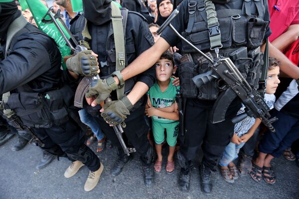 Палестинские мальчики стоят рядом с боевиками ХАМАСа, когда они принимают участие в военном шоу против недавно установленных мер безопасности Израиля при входе в мечеть аль-Акса. - Sputnik Абхазия