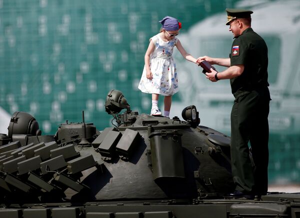 Российский военнослужащий стоит с девочкой на танке Т-72, которые демонстрируются во время церемонии открытия Международных армейских игр 2017 года в Алабино - Sputnik Абхазия