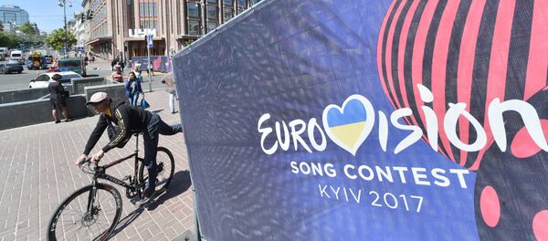 Человек едет на велосипеде мимо официального логотипа конкурса песни «Евровидение» в центре Киева Человек едет на велосипеде мимо официального логотипа конкурса песни «Евровидение» в центре Киева - Sputnik Абхазия