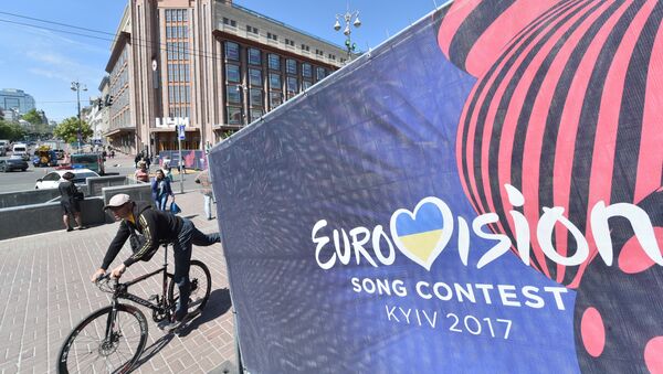 Человек едет на велосипеде мимо официального логотипа конкурса песни «Евровидение» в центре Киева - Sputnik Абхазия