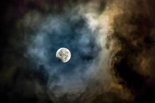 В ночь с 7-го на 8 августа жителям планеты, в том числе и казахстанцам, выпала уникальная возможность стать свидетелями лунного затмения. На этом фото запечатлена луна, обрамленная пеплом от вулкана Маунт Синабунг, во время пика затмения в северной части острава Суматра. - Sputnik Абхазия