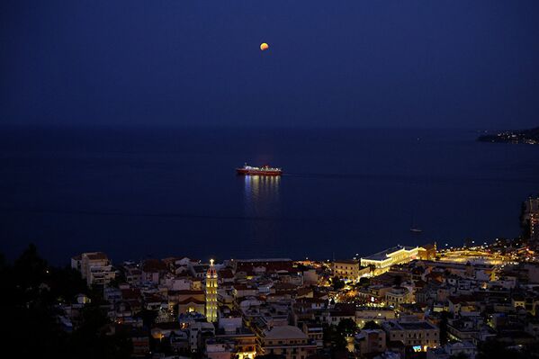 Августовская луна, наблюдаемая во время частичного лунного затмения над кораблем на греческом острове Закинтос. - Sputnik Абхазия