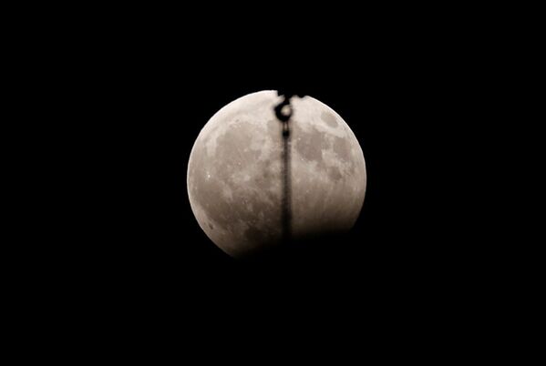 Грузоподъемный кран на фоне восходящей луны во время затмения в ливанской столице Бейруте. - Sputnik Абхазия