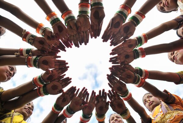 Индийские девушки надевают трёхцветные браслеты перед тем, как принять участие во время празднования Дня независимости - Sputnik Абхазия