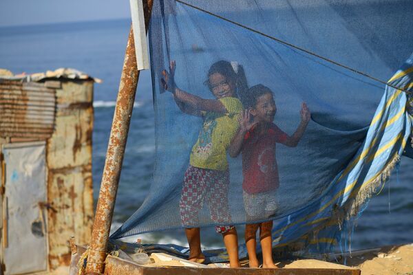 Палестинские дети играют рядом со своими домами в городе Газа - Sputnik Абхазия