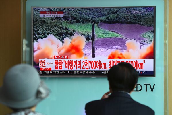 Люди наблюдают за запуском северокорейской ракеты на железнодорожной станции в Сеуле - Sputnik Абхазия