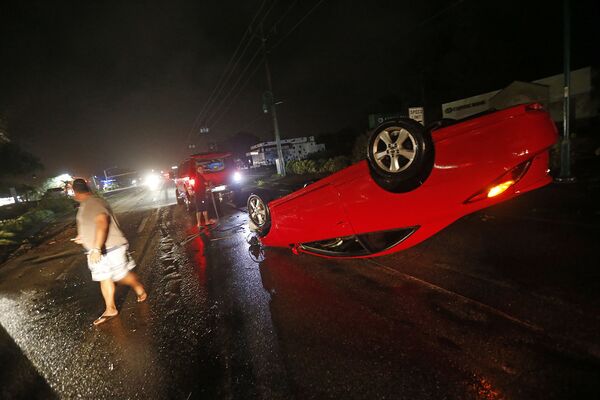 Люди возле перевернутого автомобиля в городе Кейп-Корал, штат Флорида. - Sputnik Абхазия