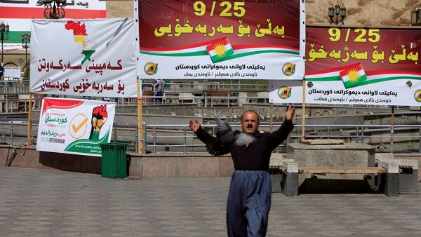 Мужчина на фоне баннеров в поддержку референдума в Курдистане - Sputnik Абхазия