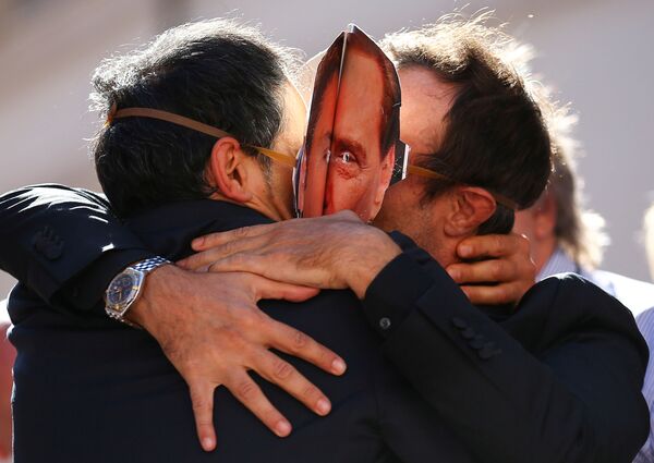 Люди в масках Сильвио Берлускони обнимают друг друга - Sputnik Абхазия