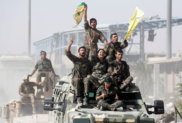 Бойцы Сирийских демократических сил празднуют победу над группировкой ДАИШ, запрещенной в России, в сирийской Ракке - Sputnik Абхазия