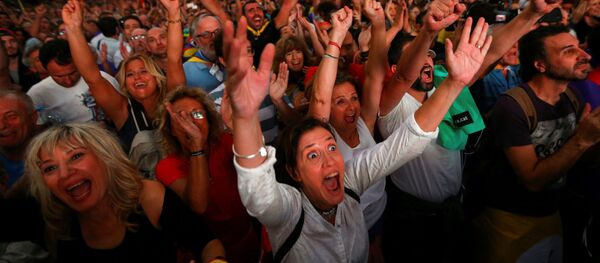 Люди смотрят трансляцию заседания Каталонского регионального парламента во время митинга за независимость в Барселоне Люди смотрят трансляцию заседания Каталонского регионального парламента во время митинга за независимость в Барселоне - Sputnik Абхазия