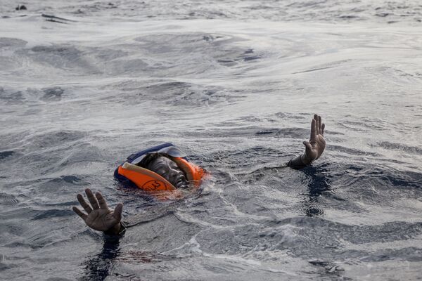 Мигрант пытается сесть на лодку немецкой НПО «Морская вахта» в Средиземном море - Sputnik Абхазия