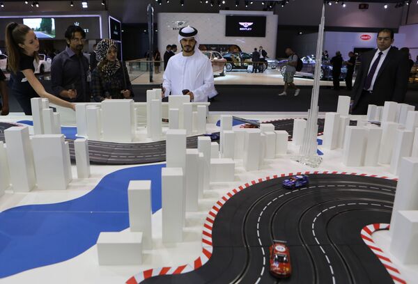 Посетитель Emirati играет с игрушечной машиной с дистанционным управлением на Международном автосалоне в Дубае - Sputnik Абхазия