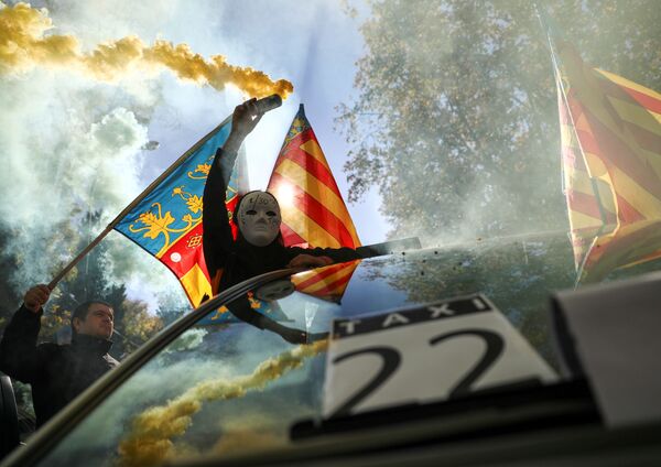 Человек в маске и дымовой шашкой во время забастовки таксистов в Мадриде - Sputnik Абхазия