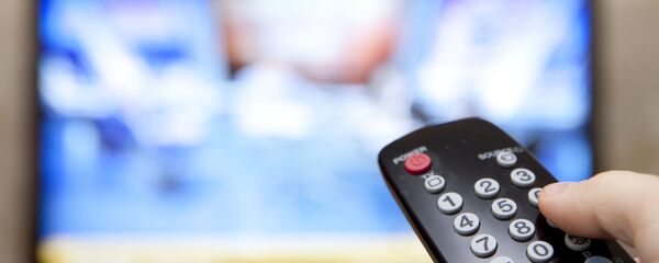 Мужчина держит пульт перед телевизором Мужчина держит пульт перед телевизором - Sputnik Абхазия