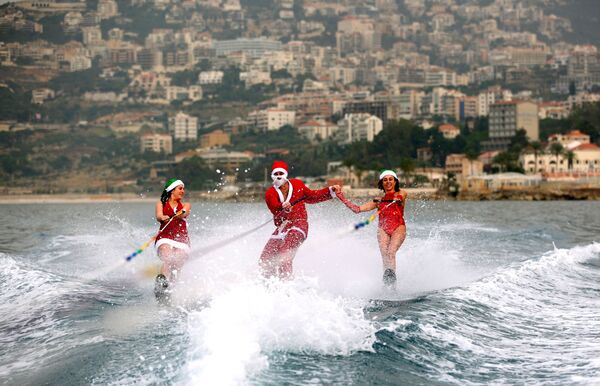 Молодые люди на водных лыжах в костюмах Санта-Клаусов в заливе Джуния, Ливан - Sputnik Абхазия