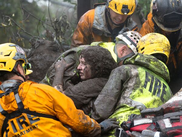 Спасатели достают женщину из под завалов ее дома, который был разрушен оползнем в Монтесито, Калифорния - Sputnik Абхазия