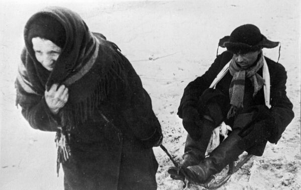 Женщина везет ослабевшего от голода мужа в дни блокады Ленинграда - Sputnik Абхазия