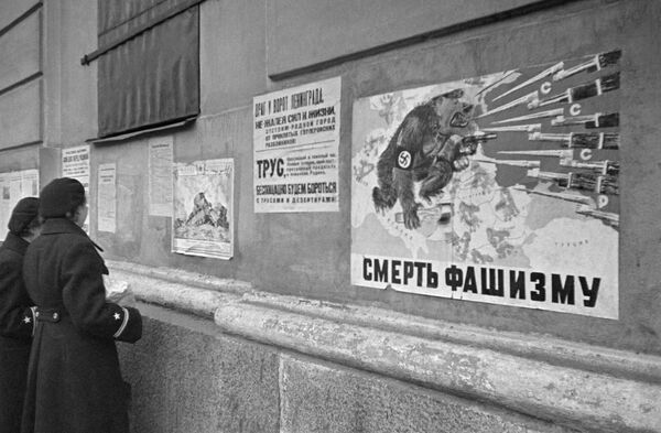 Девушки читают листовки на стене дома - Sputnik Абхазия