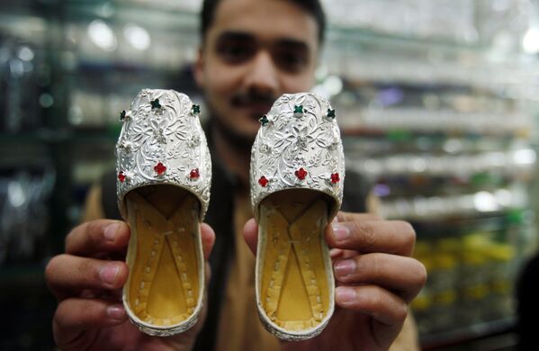 Продавец демонстрирует серебряные туфельки в ювелирном магазине на рынке в Пешаваре, Пакистан - Sputnik Абхазия