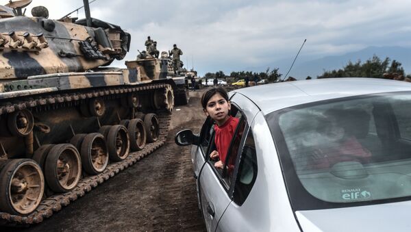 Турецкая девочка наблюдает из окна автомобиля, как танки и солдаты турецкой армии собираются у сирийской границы в городе Хасса - Sputnik Абхазия