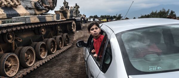 Турецкая девочка наблюдает из окна автомобиля, как танки и солдаты турецкой армии собираются у сирийской границы в городе Хасса Турецкая девочка наблюдает из окна автомобиля, как танки и солдаты турецкой армии собираются у сирийской границы в городе Хасса - Sputnik Абхазия