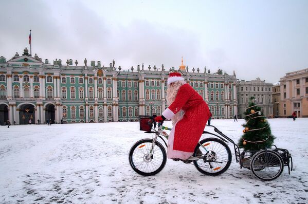 Участник на финише велопарада Дедов Морозов на Дворцовой площади в Санкт-Петербурге - Sputnik Абхазия