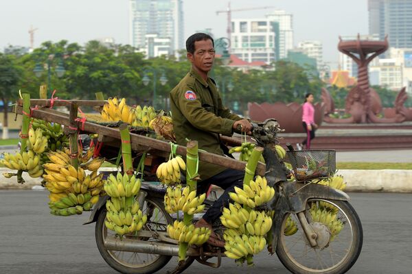 Камбоджиец на мотоцикле, груженном бананами, в Пномпене - Sputnik Абхазия