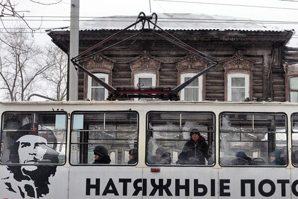 Деревянный дом и реклама на городском трамвае в Иркутске - Sputnik Абхазия