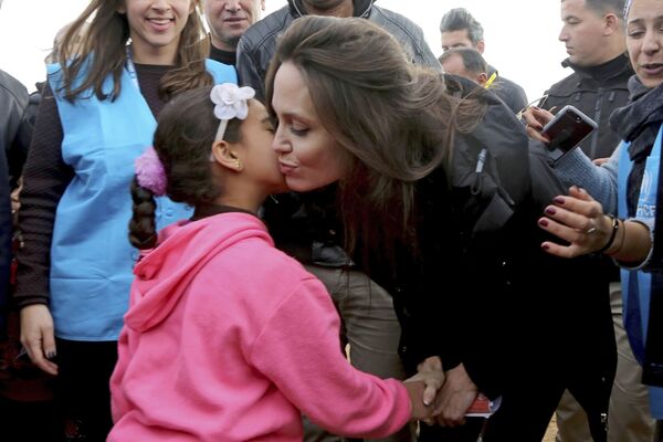 Посол доброй воли ООН актриса Анджелина Джоли целует сирийскую девочку во время визит в лагерь сирийских беженцев в городе Макфрак, Иордан - Sputnik Абхазия