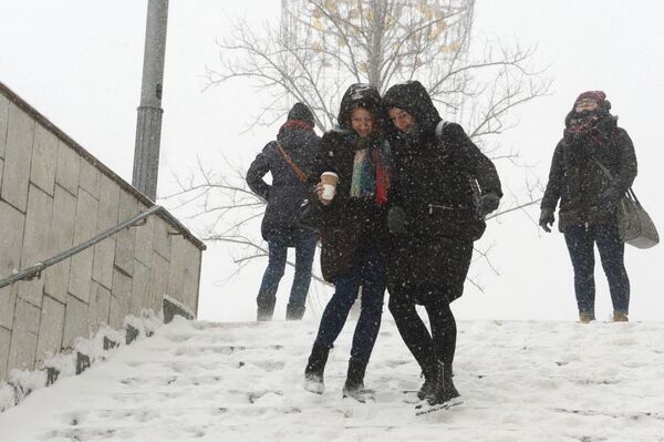 Девушки на ступеньках подземного перехода во время снегопада в Москве - Sputnik Абхазия