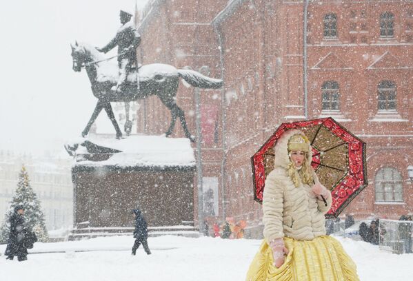 Женщина с зонтом на Манежной площади во время снегопада в Москве - Sputnik Абхазия