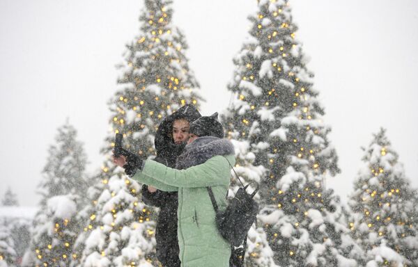 Девушки фотографируются во время снегопада на Манежной площади в Москве - Sputnik Абхазия