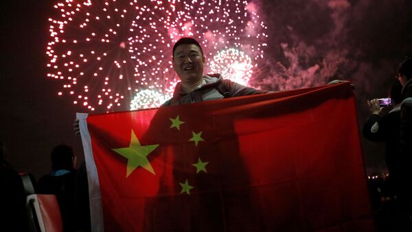 Мужчина с китайским флагом во время фейерверка в честь китайского Нового года в Нью-Йорке, США - Sputnik Абхазия