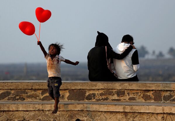 Ребенок с шариками-сердечками и пара на улице Мумбаи в День всех влюбленных - Sputnik Абхазия