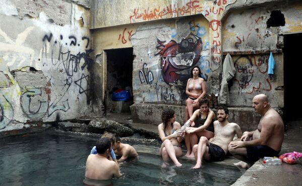 Израильтяне в бассейне с водой из горячих источников в районе спорной территории Голанских высот на границе с Иорданией - Sputnik Абхазия