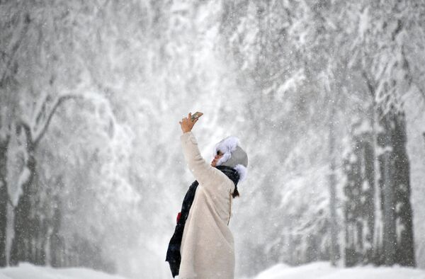 Девушка фотографируется на Воробьевых горах во время снегопада - Sputnik Абхазия