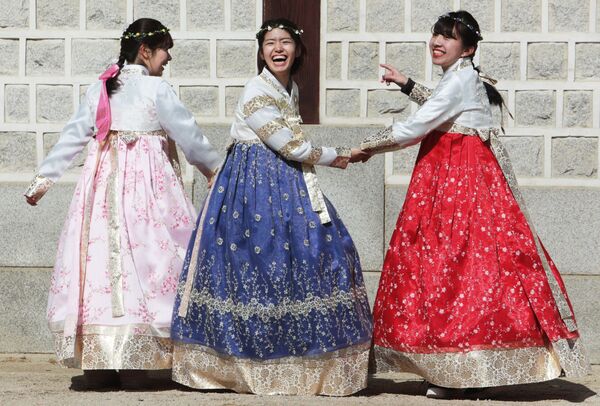 Девушки в национальной корейской одежде ханбок у королевского дворца Кенбоккун в Сеуле - Sputnik Абхазия