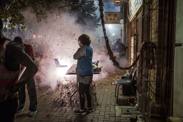 Люди запускают праздничные фейерверки, прогоняющие злых духов, во время празднования Китайского Нового года в Нью-Йорке - Sputnik Абхазия