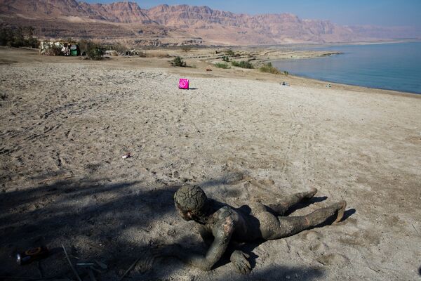 Мужчина покрытый лечебной грязью на берегу Мертвого моря недалеко от Меццока Драго, Израиль, Западный берег - Sputnik Абхазия