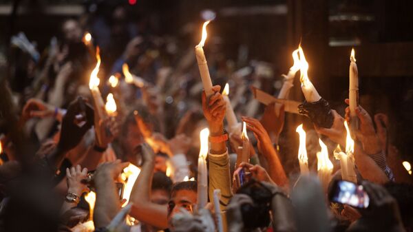 Верующие со свечами во время сошествия благодатного огня в Храм Гроба Господня в Иерусалиме - Sputnik Аҧсны