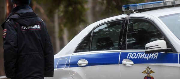 Сотрудник полиции возле служебного автомобиля - Sputnik Абхазия