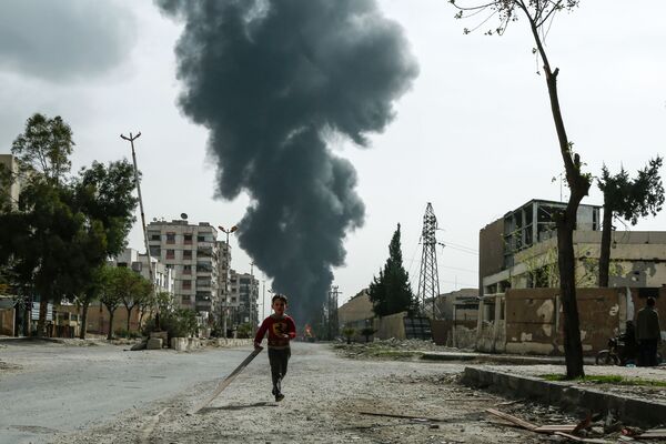 Ребенок на улице города Дума после сообщения о воздушном ударе в Восточной Гуте, Сирия - Sputnik Абхазия