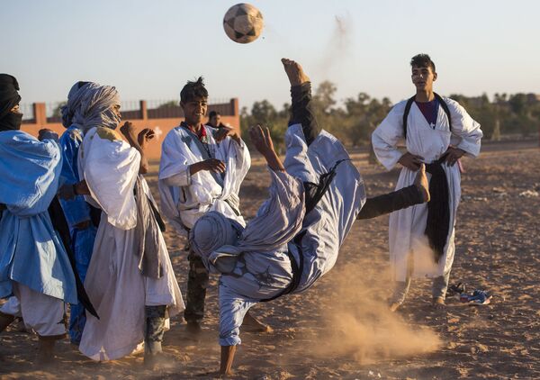 Подростки играют в футбол во время 15-го Международного фестиваля кочевников в Эль-Газлане в пустыне Сахара в Марокко - Sputnik Абхазия